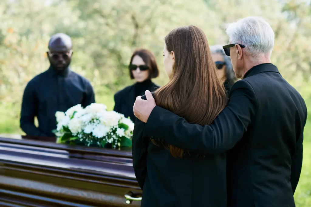 Image of people griefing around a coffin