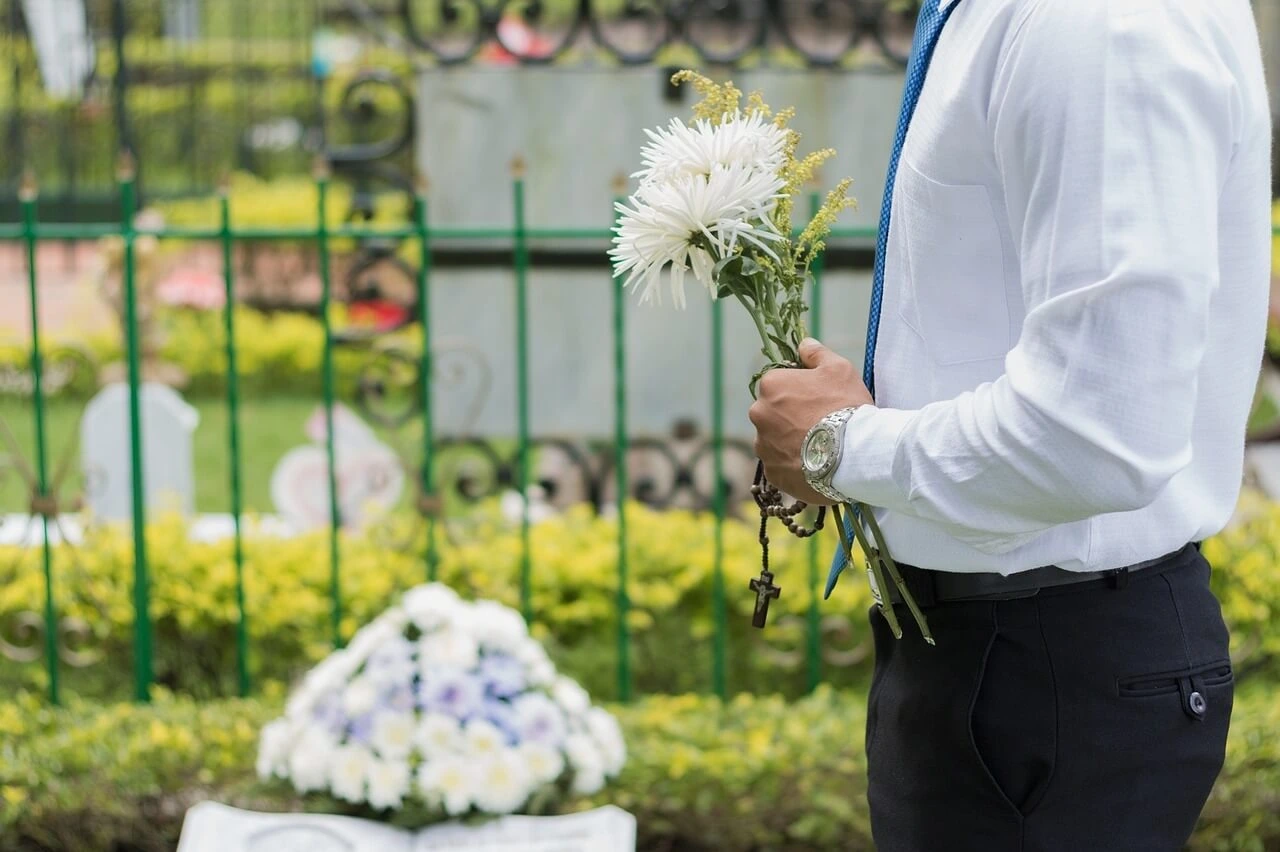 Funeral with man holding flowers